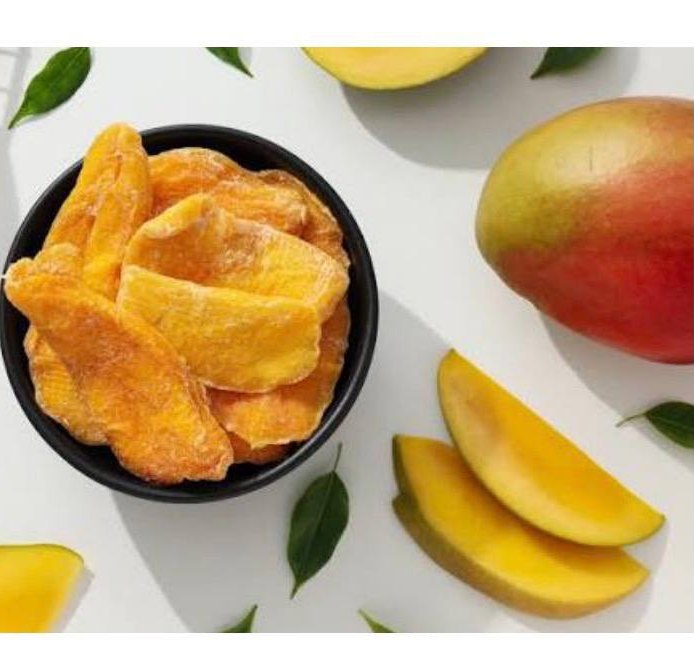 Bowl of dried mango slices with fresh mangoes